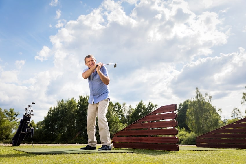 Senior man hitting golf ball