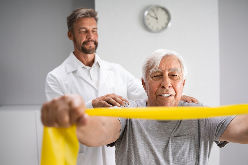 Older man getting shoulder rehab therapy
